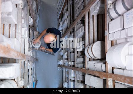 15. September 2022, Sachsen, Meißen: Sven Beyer, Leiter Formenbau, steht auf einer Leiter im Formenarchiv der Porzellanmanufaktur Meissen. Foto: Sebastian Kahnert/dpa Stockfoto