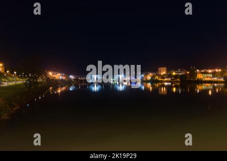 Maribor, Slowenien - 2. Juni 2022: Nächtliches Stadtbild von Maribor auf der Hauptbrücke (Stari Most) über der Drau. Stockfoto