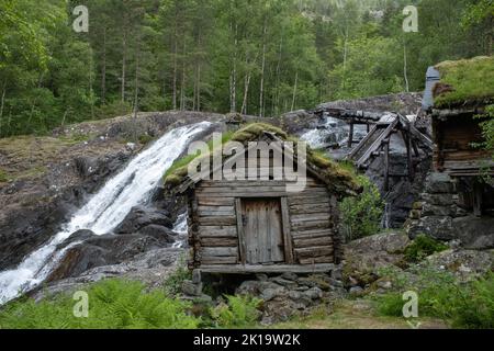 Wunderschöne Landschaften in Norwegen. Vestland. Schöne Landschaft von alten Wassermühlen auf Suldalsosen.Grasdächer. Skandinavische Landschaft. Wolkiger Tag. Stockfoto