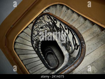 Spiralförmige quadratische Treppe blickte von unten nach oben. Vintage Treppe in alten Mietshaus. Perspektivische Ansicht von unten Stockfoto