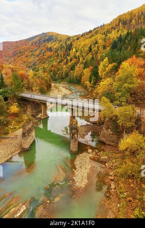 Blick auf die Eisenbahnbrücke über dem Fluss Prut. Beauteful Herbst in Karpaten, Jaremche, Ukraine Stockfoto