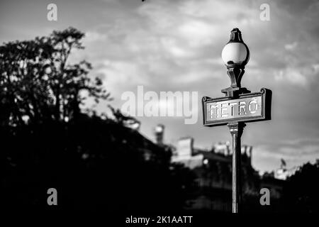 Die Abbildung zeigt ein Schild mit dem U-Bahn-Symbol vor einer pariser U-Bahn-Station (Metropolitain). Alte Zeiten, Vintage, Nostalgie-Konzept. Stockfoto