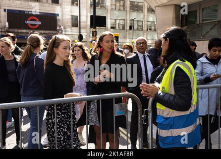 London, Großbritannien. 14.. September 2022. Frauen sprechen mit einem Sicherheitsbeamten, der in der Gegend Wache stellt, während die Menschen versuchen, einen Weg zu finden, zu beobachten, wie Sarg mit dem Leichnam von Queen Elizabeth nach dem Tod der britischen Königin Elizabeth in London, Großbritannien, am 14. September 2022 vom Buckingham Palace in die Westminster Hall verlegt wird. Kamil Jasnski/Alamy Live News Stockfoto