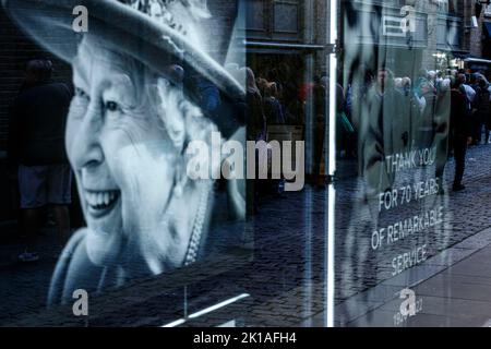 London, Großbritannien. 16. September 2022. Die Schlange spiegelt sich in einem Schaufenster wider, in dem Bilder der britischen Königin Elizabeth nach ihrem Tod in London, Großbritannien, am 16. September 2022, zu sehen sind. Kredit: ZUMA Press, Inc./Alamy Live Nachrichten Stockfoto