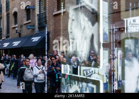 London, Großbritannien. 16. September 2022. Eine Schlange von Menschen spiegelt sich auf einem Schaufenster wider, das Bilder der britischen Königin Elizabeth nach ihrem Tod in London zeigt. Eine lange Schlange wird sich 10 Meilen über London erstrecken, und es wird erwartet, dass sich in den nächsten Tagen bis zur Beerdigung um 06:30 Uhr am Montag, dem 19. September 2022, eine Million Menschen für den im-Staat von Königin Elizabeth II. Im Palace of Westminster einfinden werden. (Foto von May James | SOPA Images/Sipa USA) Quelle: SIPA USA/Alamy Live News Stockfoto