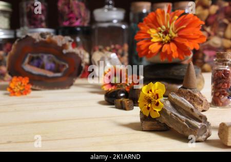 Agatisierte Koralle mit Quarzkristallen und Blumen auf Meditationsaltar Stockfoto