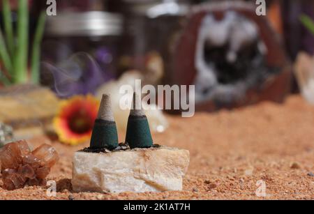 Chakra-Steine mit Aloe Vera-Pflanzen und Räucherkegel auf australischem roten Sand Stockfoto