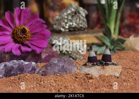 Amethyst-Kristalle und Chakra-Steine auf dem australischen roten Sand. Meditationsaltar Stockfoto