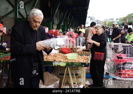 Ältere Paare, die auf dem Fresh Food Market von Paddy in Flemington, Sydney, New South Wales, Erdnüsse und frisches Obst und Gemüse einkaufen Stockfoto