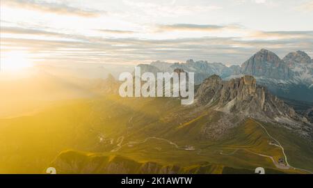 Blick von oben, atemberaubende Luftaufnahme des Giau-Passes bei einem wunderschönen Sonnenuntergang. Der Giau Pass ist ein Hochgebirgspass in den Dolomiten Stockfoto