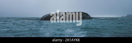 Ein riesiger Öltanker fällt ins Meerwasser, ökologische Katastrophe unter blauem Himmel Stockfoto