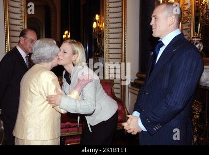 Das Filepoto vom 19/12/06 von Queen Elizabeth II begrüßt die Enkelin Zara Phillips, während der Herzog von Edinburgh (links) und Zaras Freund, der englische Rugby-Spieler Mike Tindall, bei einem Empfang im Buckingham Palace zu Ehren der besten Leistungsträger des Landes aufblicken. Der verstorbene Monarch hatte acht Enkelkinder, die am Samstag eine Mahnwache um ihren Sarg durchführen, und 12 Urenkel. Die Königin war Großmutter von acht Enkelkindern, die alle ihren Oma einen tiefen Respekt und Bewunderung entgegenhielten. Peter Phillips, Zara Tindall, der Prinz von Wales, der Herzog von Sussex, Prinzessin Beatrice, Prinzessin Eugenie, Stockfoto