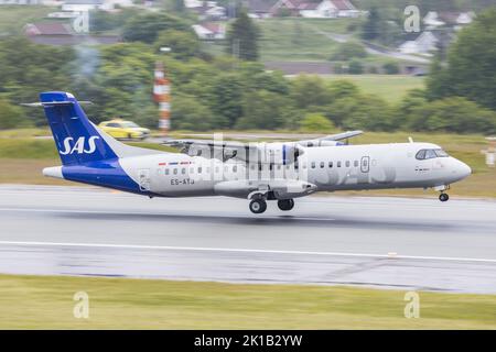 Ein ATR-72 Turboprop-Flugzeug von SAS Scandinavian Airlines, das auf einer nassen Start- und Landebahn in Kristiansand in Norwegen landet Stockfoto