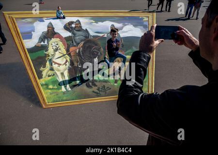 Moskau, Russland. 12.. September 2022. Kinder reiten auf einer Nachbildung des Gemäldes „Bogatyrs“ von Viktor Vasnetsov aus dem Jahr 3D auf der Ausstellung der Errungenschaften der Volkswirtschaft (VDNH) in Moskau, Russland Stockfoto