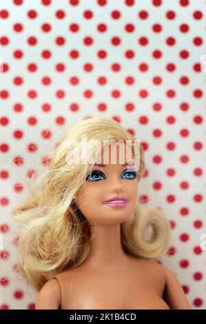 Blonde Barbie Puppe Gesicht vor einem Punktmuster Hintergrund Stockfoto