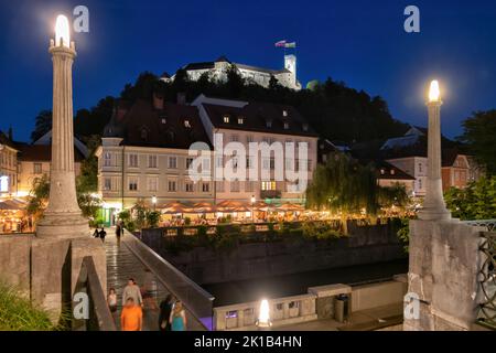 Stadt Ljubljana bei Nacht in Slowenien, Blick auf den Burgberg und die Fischmarktbrücke auf dem Fluss Ljubljanica. Stockfoto