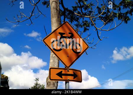 Orangefarbenes Radwegeschild vor blauem Himmel in Brisbane, Australien Stockfoto