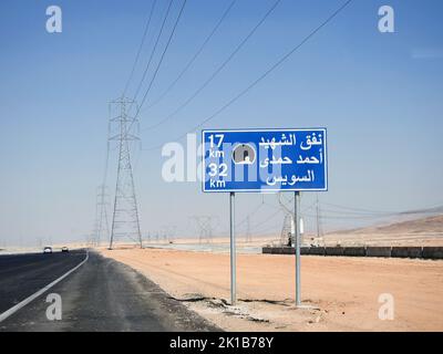 Suez, Ägypten, August 12 2022: Ein Straßenschild in Suez Kairo Autobahn in Arabisch, Übersetzung (Martyr Ahmed Hamdi Tunnel 17 KM, Suez 32 KM), Ahmed Hamdy Stockfoto