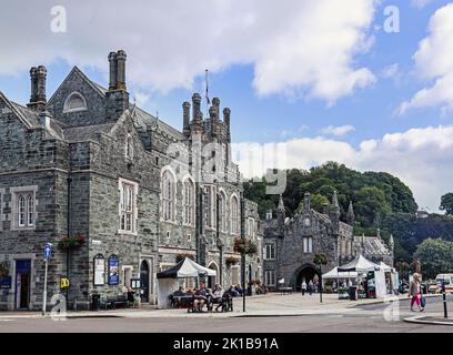 Tavistock Town Hall und Torbogen zum Markt, Bedford Square. Entworfen von Edward Rundle Architekt eröffnet mit einem Grand Ball 1864. Einkäufer ruhen sich aus Stockfoto