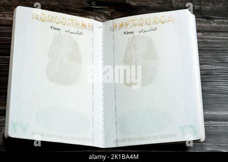 Ägyptischer Pass isoliert auf hölzernen Hintergrund, Pass der Arabischen republik Ägypten mit dem republikanischen goldenen Adler auf dem Deckel und König Tutanchamun Stockfoto