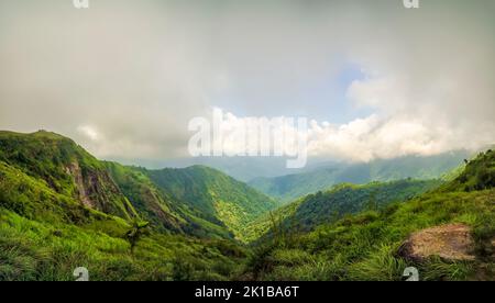 Dicke Monsunwolken schweben über üppig grüne Berge mit tiefer Schlucht am Stadtrand von Mawsynram, East Khasi Hills, Meghalaya, Indien. Stockfoto