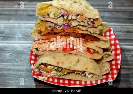 Stapel ägyptischer beliebter Street Sandwiches mit pürierten Fava-Bohnen, frittierten knusprigen Falafel-Bällen, frittierten Kartoffelfingern mit grünem Salat, baba ghanasch r Stockfoto