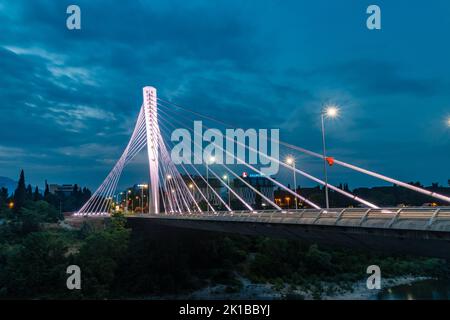 Podgorica, Montenegro - 4. Juni 2022: Beleuchtete Millennium-Brücke über den Fluss Moraca in der Nacht. Stockfoto