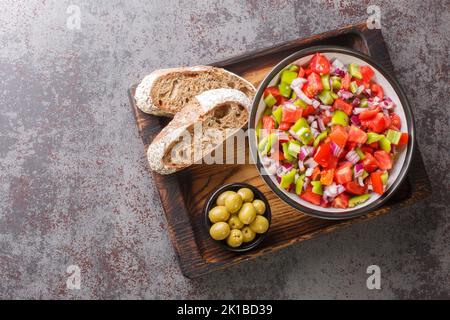 Der Trampo ist ein typischer Paprika-Tomaten-Salat auf Mallorca Spanien, der auf dem Holzbrett auf dem Tisch liegt. Horizontale Draufsicht von oben Stockfoto