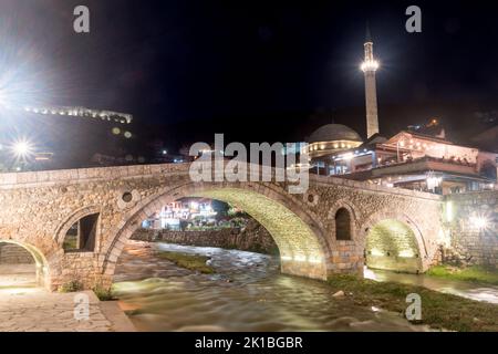 Prizren, Kosovo - 4. Juni 2022: Bistrica Fluss und Alte Steinbrücke bei Nacht. Stockfoto