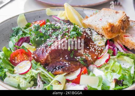 Asiatischer Salat mit gegrilltem Lachs, mariniert in Sojasouce und Sesam Stockfoto