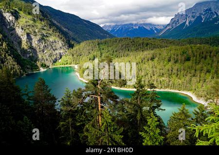 Malerischer smaragdgrüner Alpensee Blindsee, umgeben von üppigem grünen Wald am Fuße des Fernpasses, der Österreich mit Deutschland (Tirol, Österreich) verbindet Stockfoto