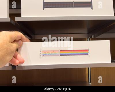 Paris, Frankreich - 16. Sep 2022: POV-Männerhandpackage im Apple Store mit neuem Pride-Band für die Apple Watch Series 8 und höher Stockfoto