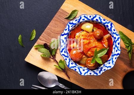 Thai Food Konzept Roasted Chicken Red, auf Holzbrett auf schwarzem Hintergrund mit Kopierfläche Stockfoto