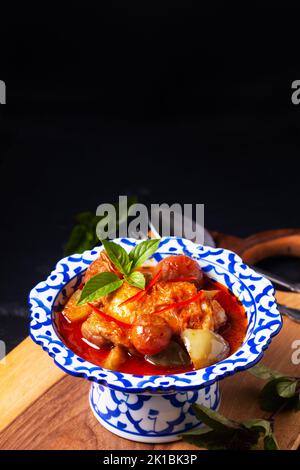 Thai Food Konzept Roasted Chicken Red, auf Holzbrett auf schwarzem Hintergrund mit Kopierfläche Stockfoto