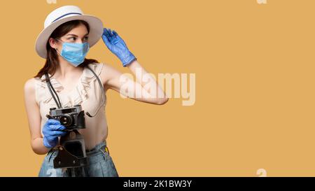 Sommerurlaub. Halten Sie Momente fest. Covid-19-Beschränkung. Besorgt Frau in Schutzmaske Handschuhe bereit für das Fotografieren auf Retro-Kamera suchen Kopie SPAC Stockfoto