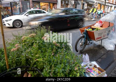 Deutschland. 17. September 2022. 17. September 2022, Hessen, Frankfurt/Main: Ein Auto fährt während der Aktion "Park-Platz statt Parkplatz! - 7. Park(ing) Day' in der Berger Straße fährt ein Auto an einem Parkplatz mit Lastenrädern vorbei. Der Parking Day ist ein jährlicher internationaler Aktionstag für die Re-Urbanisierung von Stadtzentren. Parkplätze in öffentlichen Straßen werden vorübergehend anders genutzt – zum Beispiel als grüne Oase, als Restaurant oder als Sitzbereich. Foto: Sebastian Gollnow/dpa Kredit: dpa picture Alliance/Alamy Live News Stockfoto