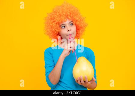 Portrait von teen Kind Mädchen halten Zitrusfrüchte Pummelo oder Pomelo, große Grapefruit isoliert auf gelbem Hintergrund. Stockfoto