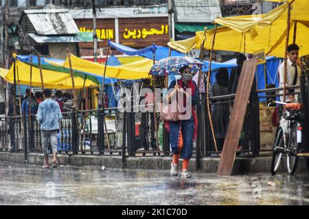 Srinagar, Indien. 17. September 2022. Während eines Niederschlags in Srinagar laufen die Menschen eine Straße entlang. (Foto: Mubashir Hassan/Pacific Press) Quelle: Pacific Press Media Production Corp./Alamy Live News Stockfoto