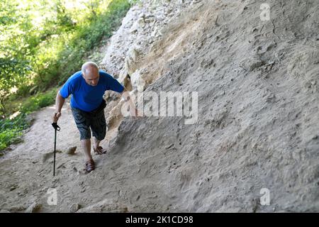 Senior man klettert entlang des Canyon-Pfades zu den Rufabgo-Wasserfällen, Adygea Stockfoto