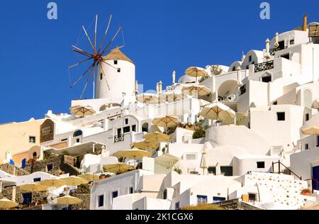 Malerisches Dorf Oia mit vielen Sonnenschirmen auf der Insel Santorini in Griechenland Stockfoto