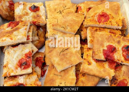 Frisch gebackene hausgemachte Apulian Focaccia in Scheiben geschnitten Draufsicht. Barese Focaccia mit Tomaten, Rosmarin, nativem Olivenöl extra und Salzflocken. Itali Stockfoto