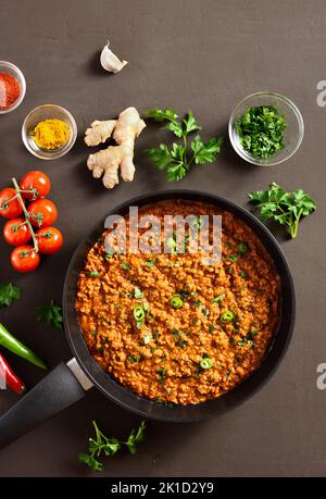 Keema-Kerk in der Pfanne auf dunklem Hintergrund. Indische und pakistanische Gerichte. Draufsicht, flach liegend Stockfoto