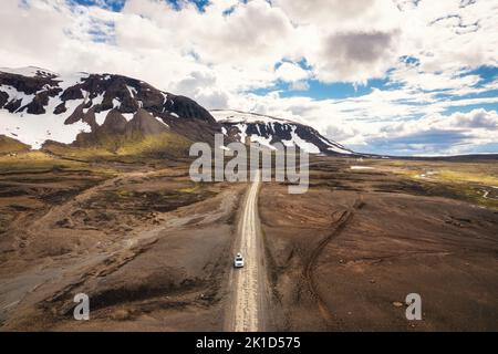 Luftaufnahme eines Roadtrip mit einem 4x4-Auto auf einer unbefestigten Straße zwischen abgelegener Wildnis auf vulkanischem Gebiet im isländischen Hochland im Sommer in Landmannalaugar, Island Stockfoto