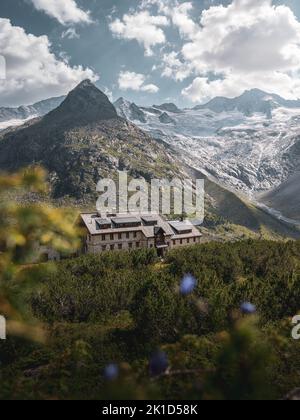 Eine vertikale Aufnahme der Berliner Hütte in den österreichischen Alpen vor dem Hintergrund hoher Berge Stockfoto