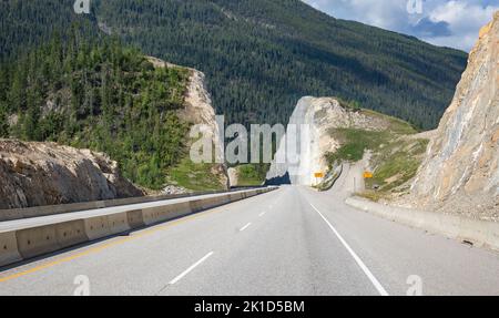 Fahrt durch Kanada auf leerer Straße mit abfahrenden LKWs. Stockfoto