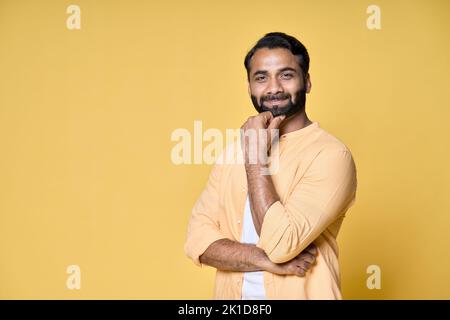 Selbstbewusster bärtiger indischer Mann, der isoliert auf gelbem Hintergrund steht. Stockfoto