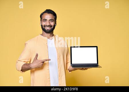 Glücklicher indischer Geschäftsmann Student zeigt auf Laptop-Modell isoliert auf gelb. Stockfoto
