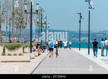 Ein sportlicher älterer Mann mit Fahrrad, der am Ufer entlang läuft, Rückansicht. Gesunder Lebensstil Stockfoto
