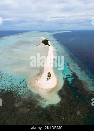 Eine vertikale Drohnenansicht einer kleinen Sandinsel mit Korallen in der Nähe eines Ufers in Semporna, Malaysia Stockfoto