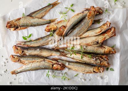 Salzige geräucherte Sprossen als Vorspeise am Meer. Geräucherter Fisch, mariniert mit Salz und Kräutern. Stockfoto